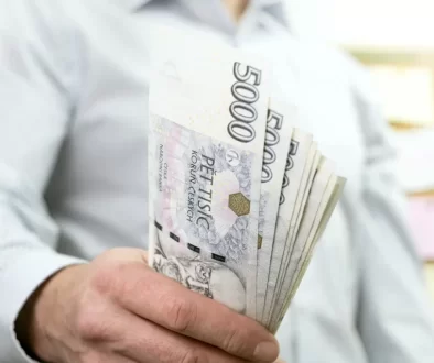 Muž držící bankovky o hodnotě 5 000 Kč