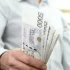 Muž držící bankovky o hodnotě 5 000 Kč