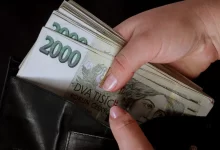 Ruka vyndávající dvoutisícové bankovky z peněženky