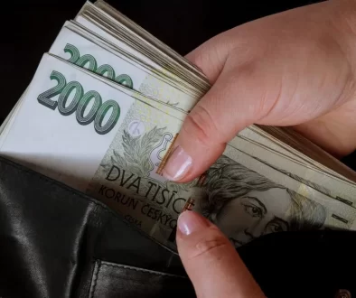 Ruka vyndávající dvoutisícové bankovky z peněženky