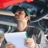 Technik při kontrole spodní části vozidla během STK