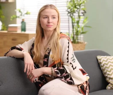 Žena sedící na gauči s rostlinami v pozadí