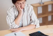 Žena se trápí nad svými financemi