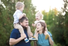 Táta a máma na procházce s dětmi za krkem