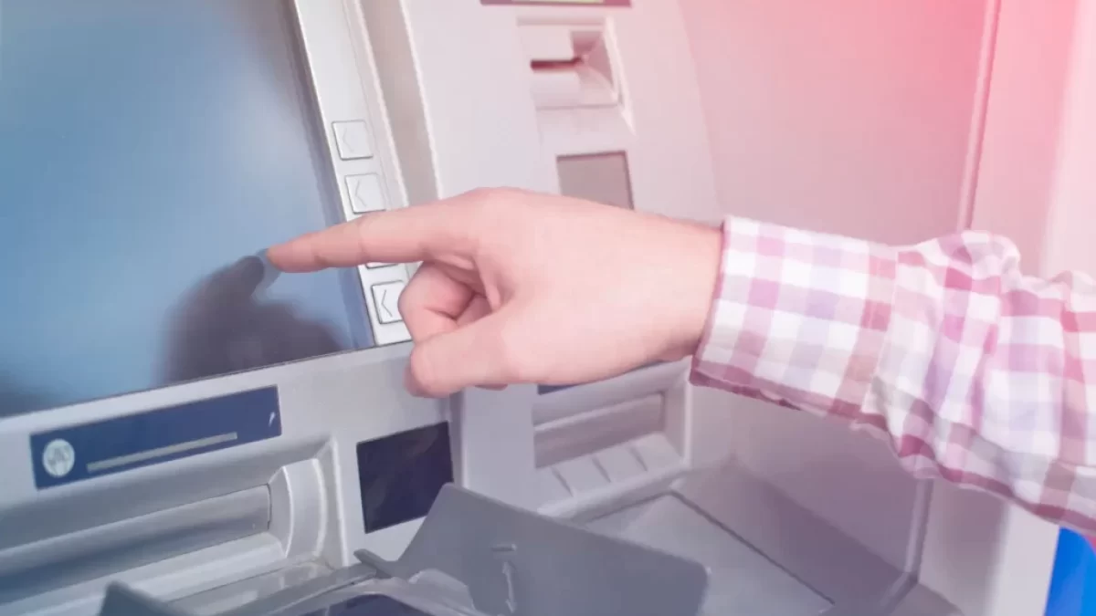 Mužská ruka ukazující na dosplej bankomatu