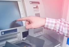 Mužská ruka ukazující na dosplej bankomatu