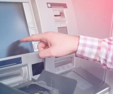 Mužská ruka ukazující na dosplej bankomatu