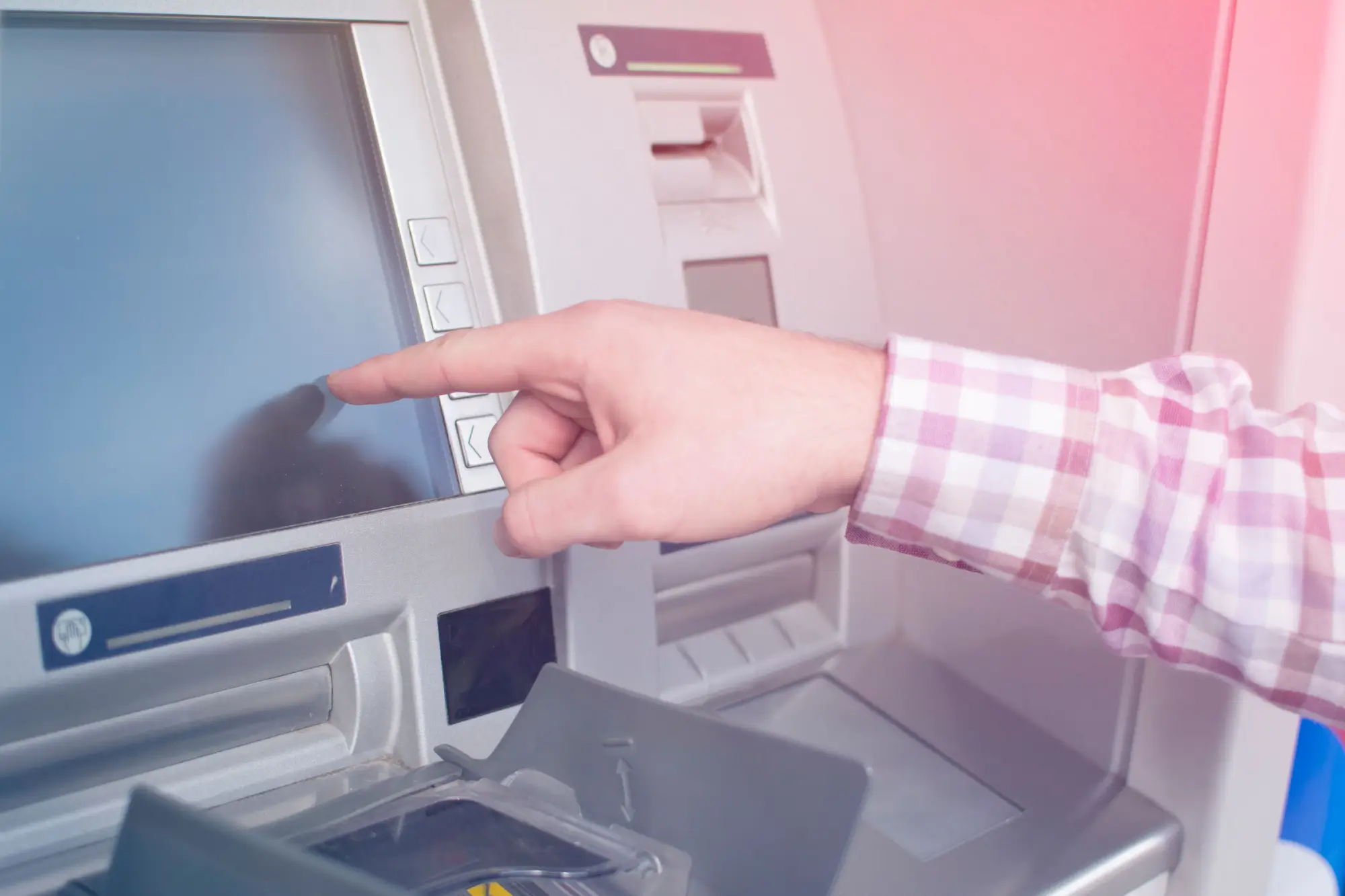 Mužská ruka ukazující na dosplej bankomatu