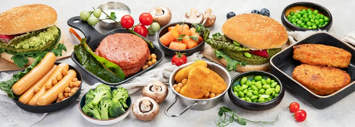 Vegan 3 - SportDeník Stůl plný vegetariánských a veganských potravin včetně burgerů