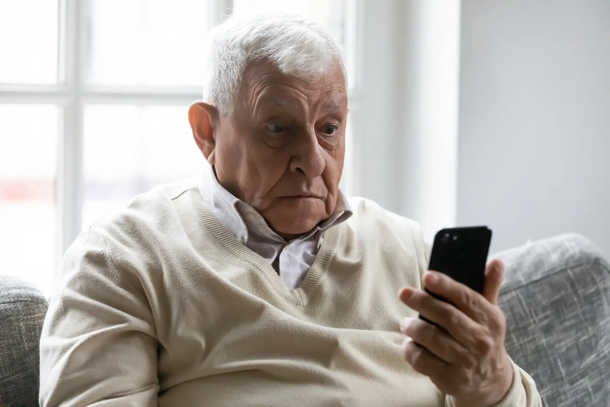 zděšený senior kouká do telefonu