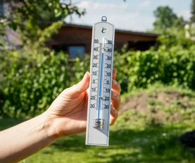 teploměr v ruce zobrazující teplotu 30 stupňů