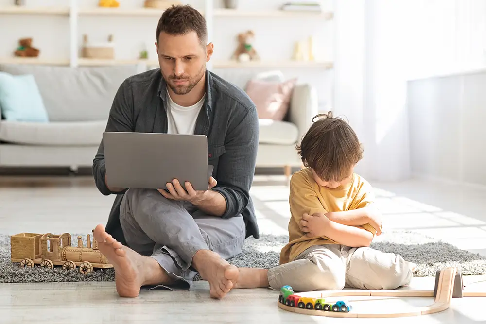 Naštvané dítě, že si s ním pracující otec nechce hrát