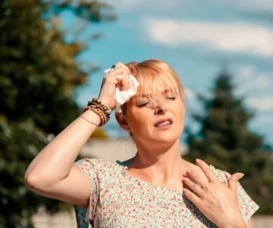 žena si v horku otírá obličej