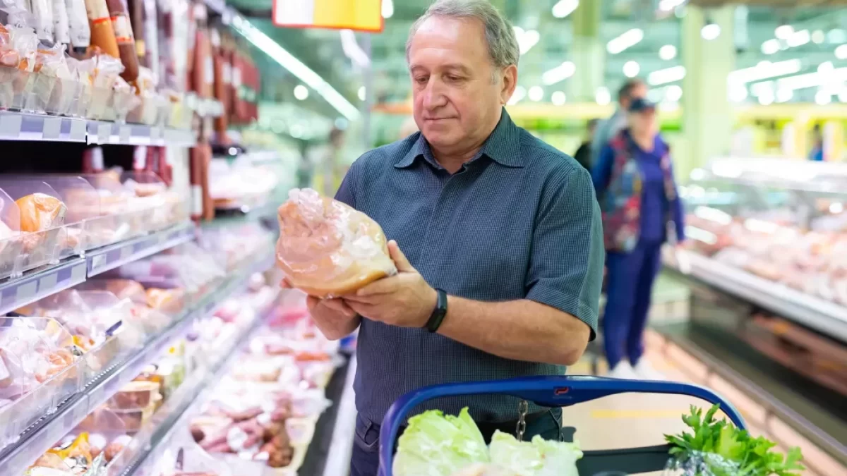 muž kupuje maso v obchodě