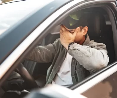 nešťastný muž za volantem auta