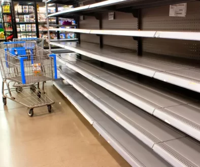 Nákupní košík v obchodě u prázdného regálu