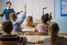 Děti sedící ve škole a jejich učitel