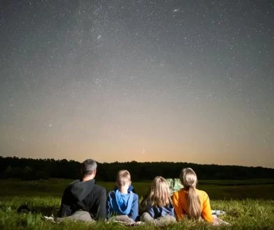 Rodina pozorující noční oblohu z louky