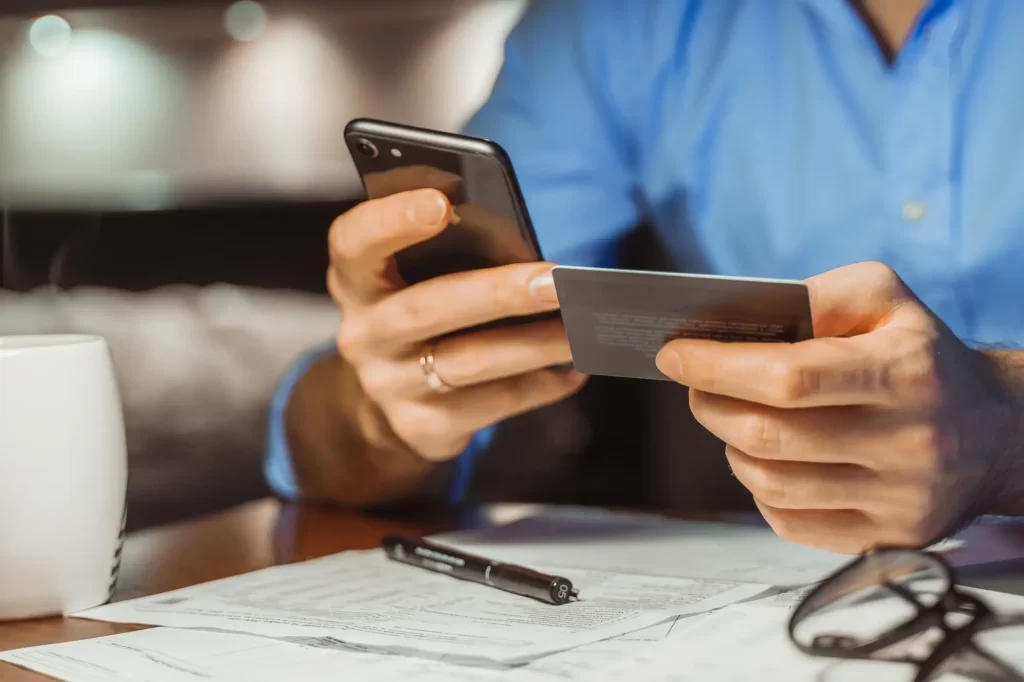 - SportDeník Osoba kontroluje platební údaje na mobilním telefonu před odesláním platby kartou.