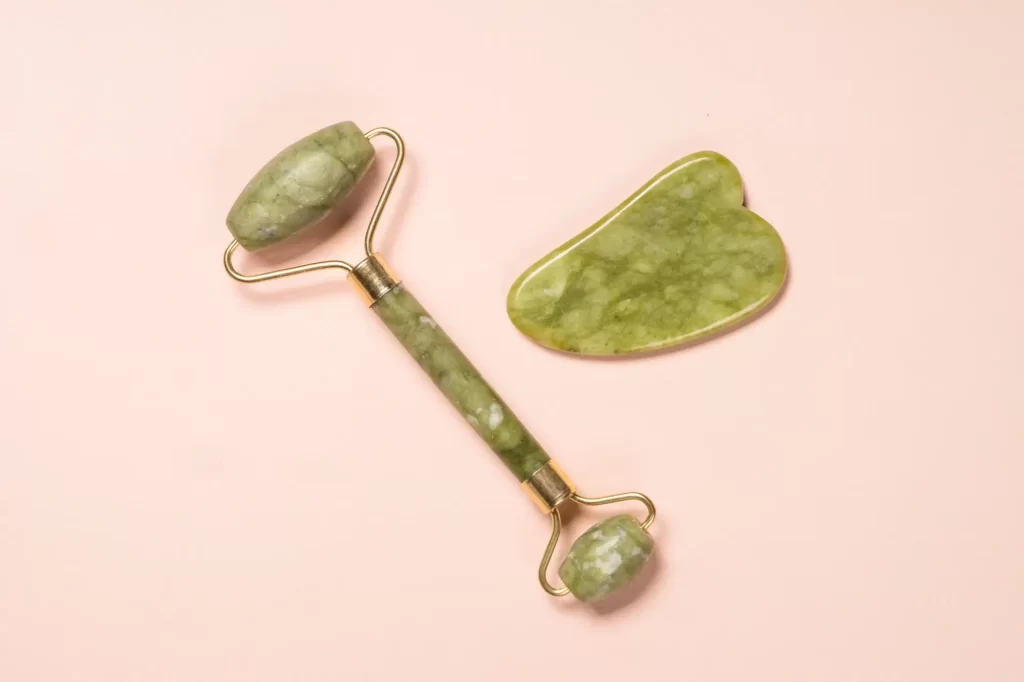 Přírodní kámen gua sha a face roller používaný k masáži obličeje.
