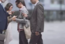 Lidé na ulici s mobilními telefony v ruce.