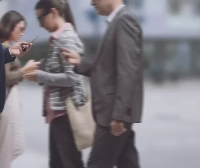 Lidé na ulici s mobilními telefony v ruce.