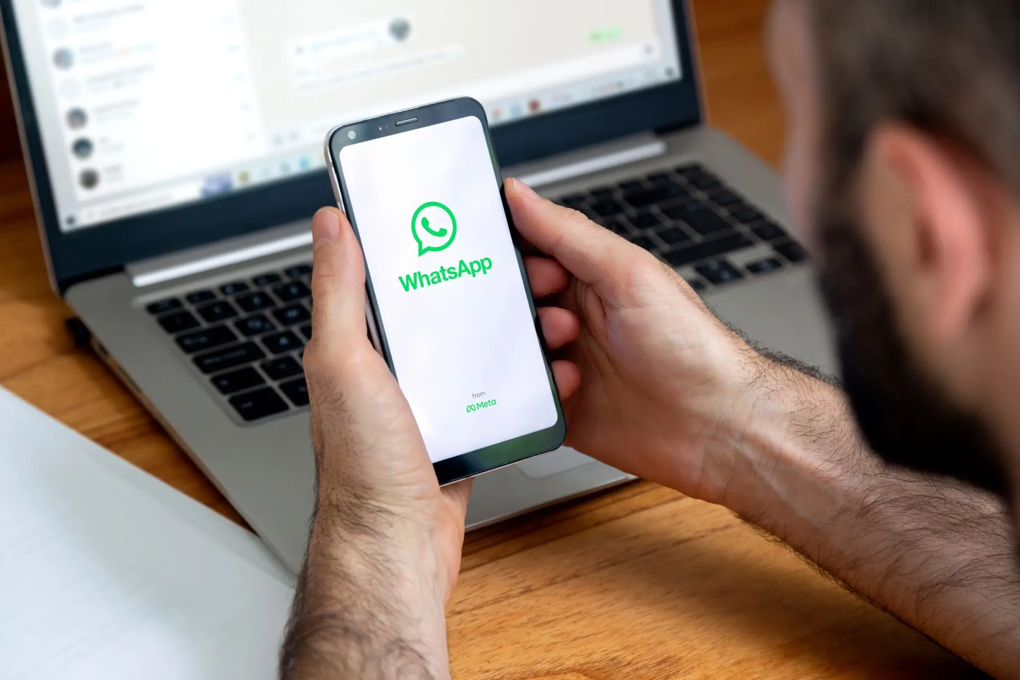 Muž s WhatsApp na mobilu i počítači