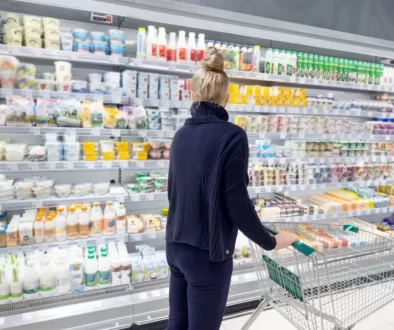 Žena před regálem s mléčným výrobky