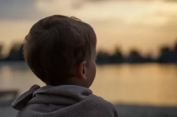 Malý chlapec se dívá na vodu