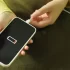 Ruce strkající koncovku nabíječky do vybitého telefonu