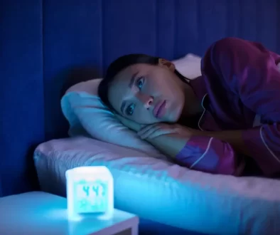 žena ležící na posteli u rozsvícené lampy
