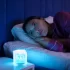 žena ležící na posteli u rozsvícené lampy