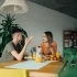 Napjatá atmosféra mezi mužem a ženou v moderní kuchyni, sedí u stolu obklopeni pokojovými rostlinami.
