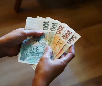 Žena drží v ruce peníze
