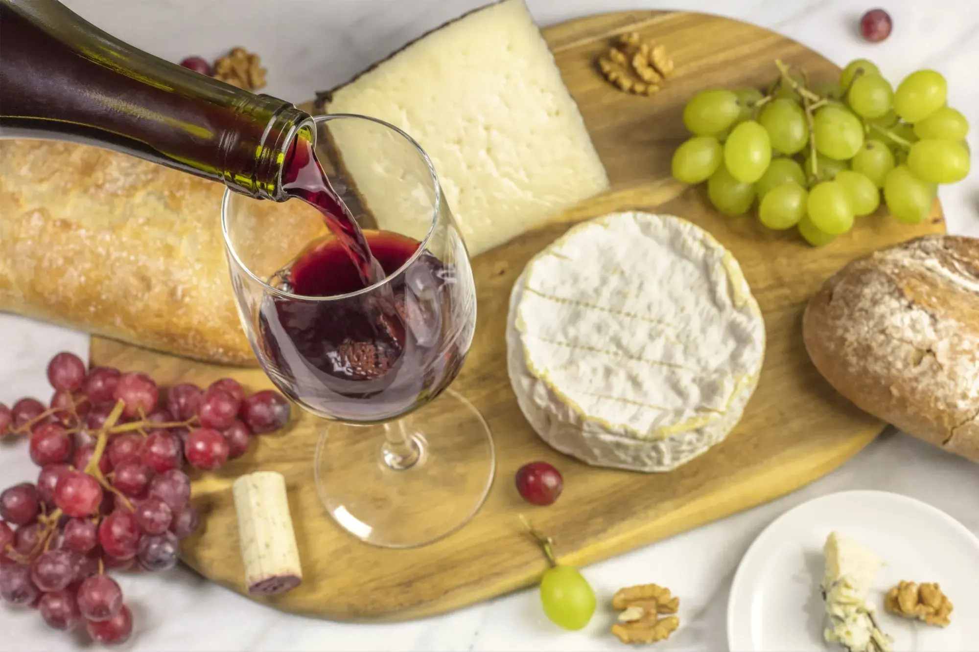 Oblíbená položka na restauračním menu, nebo zabiják spánku? Zdroj: Shutterstock - SportDeník Sýry na prkénku a sklenice vína