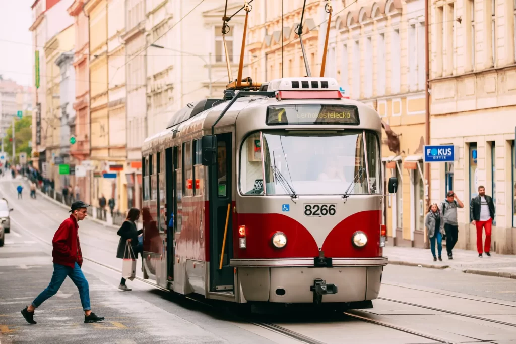 - SportDeník Pražská tramvaj T3 projíždějící centrem města, pohled z ulice s chodci.