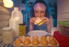 Mladá atraktivní žena se cpe v noci jídlem z lednice