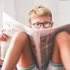 Asi desetiletý blonďatý chlapec sedí na sedačce a půl obličeje mu zakrývá časopis