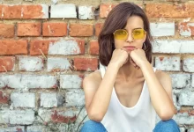 kritická mladá žena se žlutými brýlemi