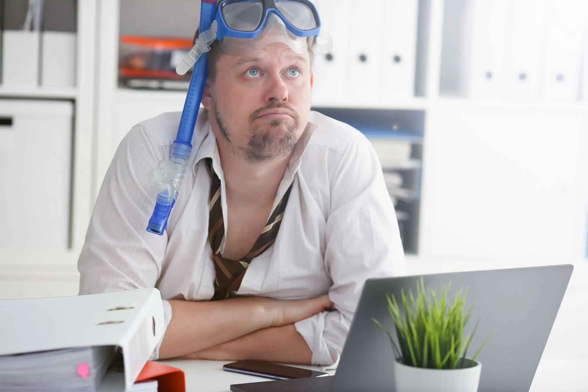 muž s potápěčskými brýlemi v kanceláři