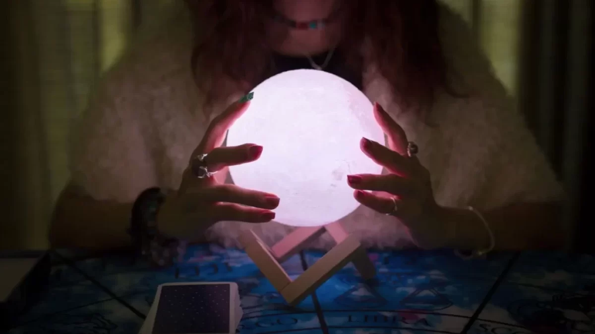 věštkyně zkoumá magickou kouli