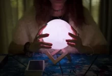 věštkyně zkoumá magickou kouli