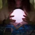 věštkyně zkoumá magickou kouli