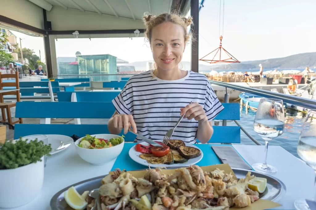 Chorvatsko je známé svou specifickou kuchyní, kterou si mnoho turistů zamilovalo. - SportDeník žena si užívá jídlo v restauraci u moře