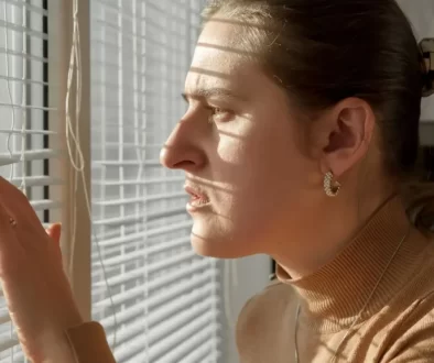 ustaraná žena dívající se z okna ven