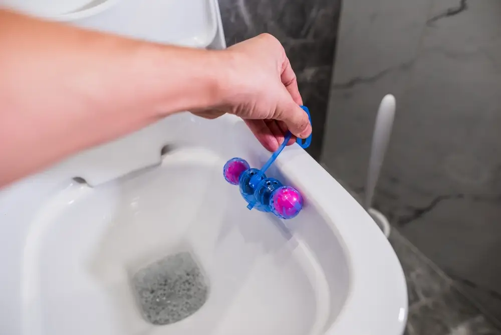 Muž dává do záchodu WC kuličky