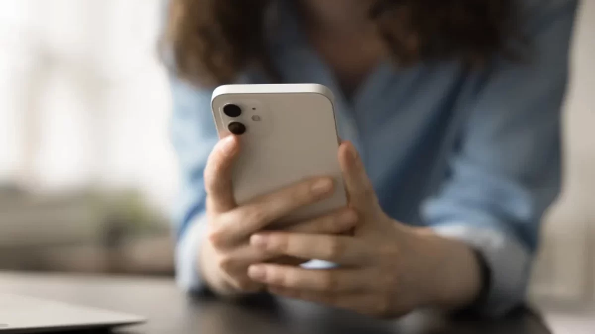 žena drží v ruce telefon