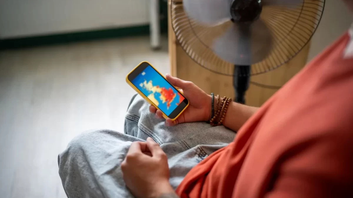 člověk sleduje předpověď počasí na telefonu