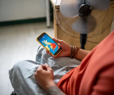 člověk sleduje předpověď počasí na telefonu