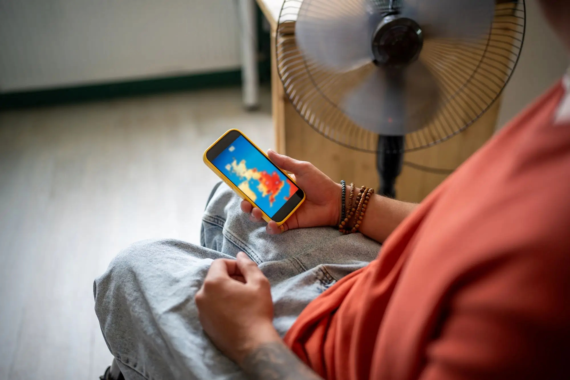 člověk sleduje předpověď počasí na telefonu